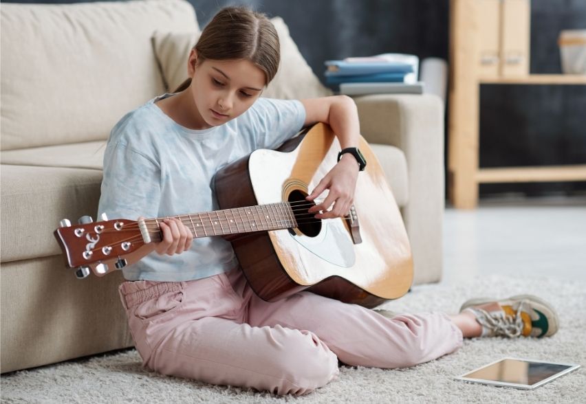 child playing acoustic guitar